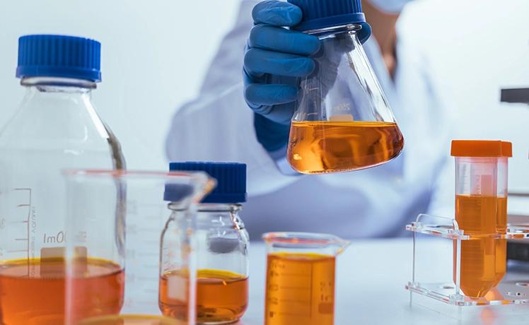 Lab technician holding diesel fuel in beakers