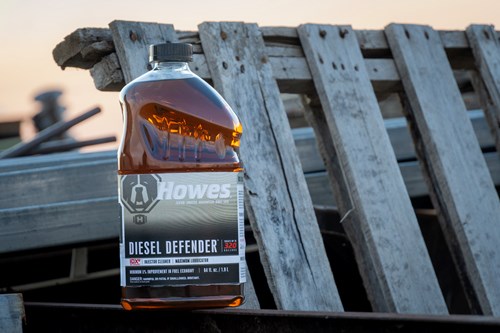 Howes Diesel Defender 32oz Bottle sitting in front of an old pallet on a farm