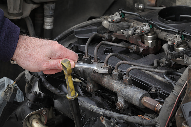 Hand of a diesel mechanic working on an engine