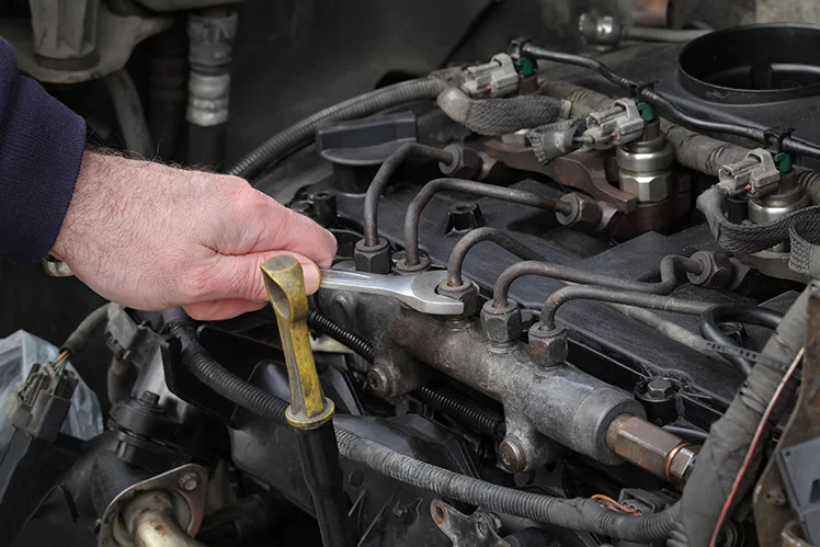Hand of a diesel mechanic working on an engine