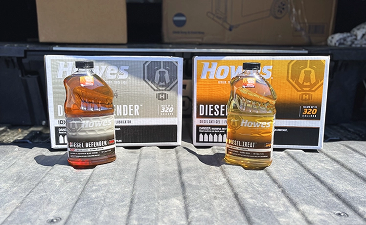 A bottle of Howes Diesel Defender and a bottle of Howes Diesel Treat each sitting in front of their cases.