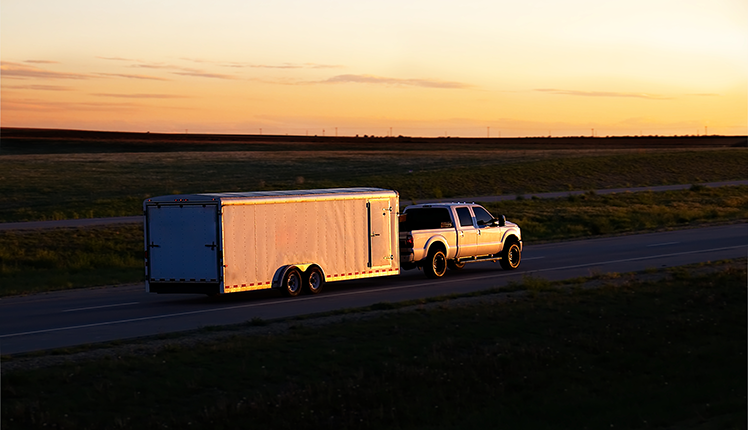 Diesel pickup truck towing a trailer on the highway